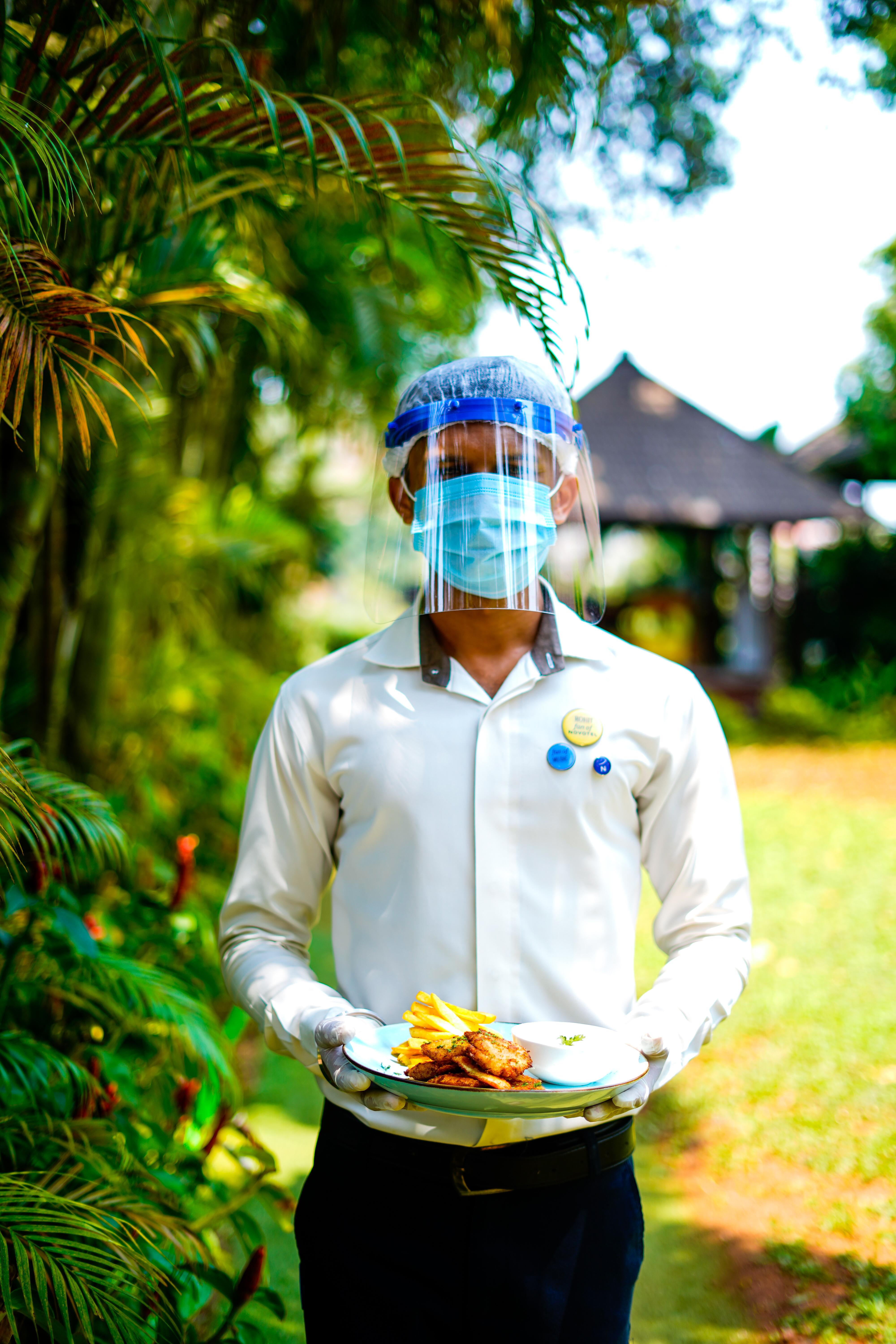 Novotel Goa Resort & Spa Candolim Εξωτερικό φωτογραφία A hotel employee wearing a face shield and a face mask